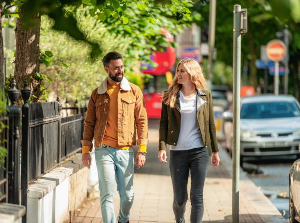 a couple in their 30s enjoying a chat in the early autumn london sunshine.